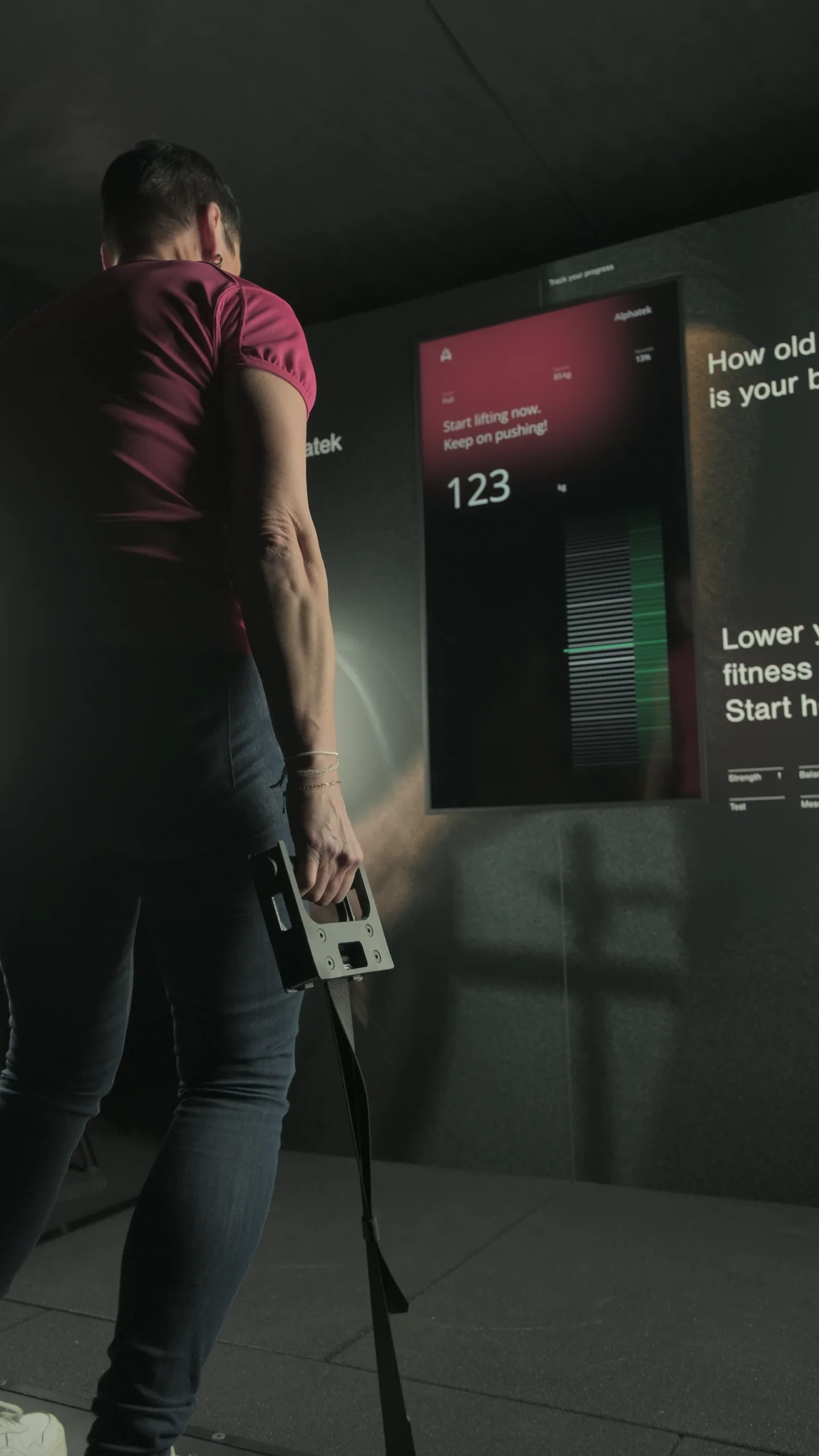 An adult completes a guided strength activity on Alphatek.